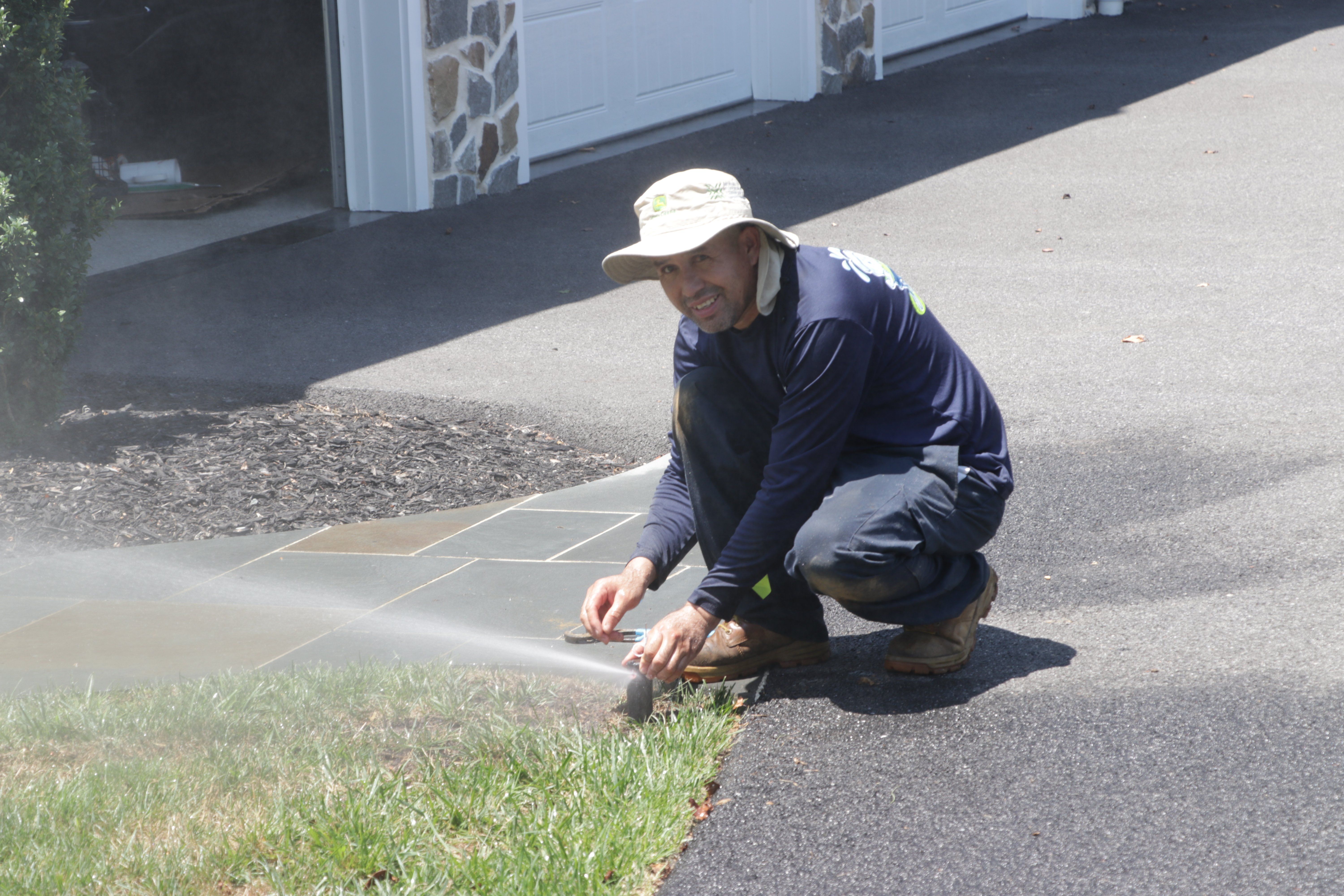 tlc service technician installing a lawn sprinkler system