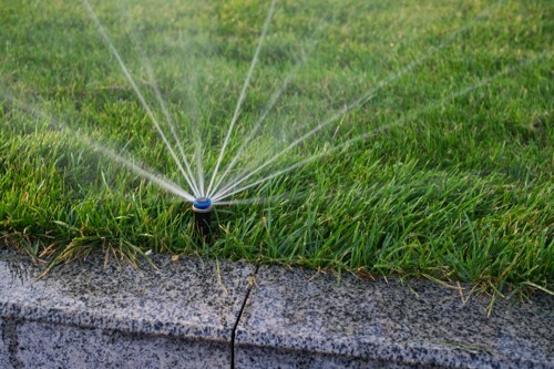 lawn sprinkler system watering green grass