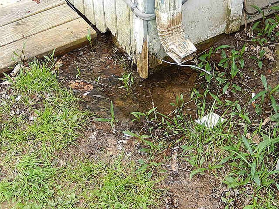 wet soggy yard next to homes foundation